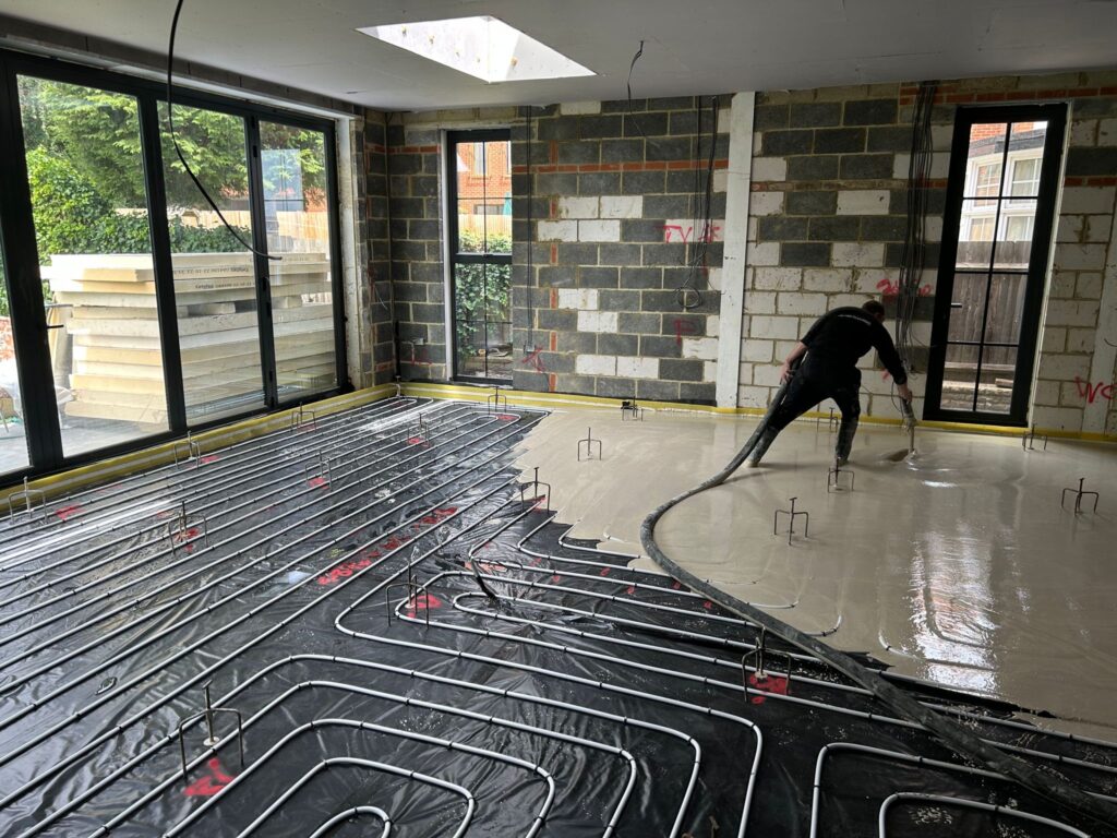 builder laying screed floor over underfloor heating