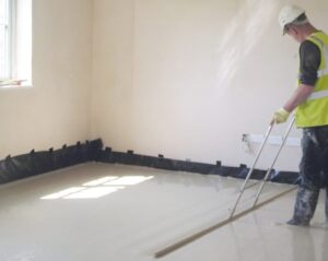 Builder laying screed floor